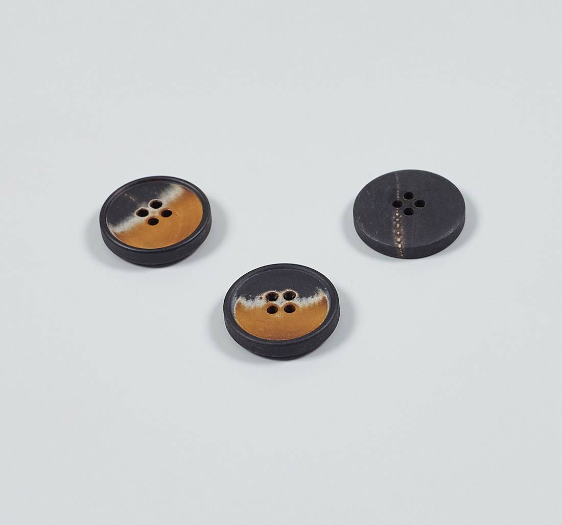 Пуговица на 4 прокола из натурального рога, матовая, наполовину — коричневая, наполовину — темно-серая в наличии
