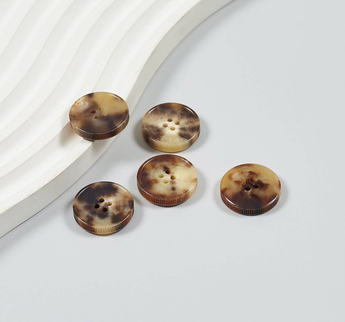Пуговица на 4 прокола из натурального рога, блестящая, рифленый гурт. Цвет светло-коричневый в наличии