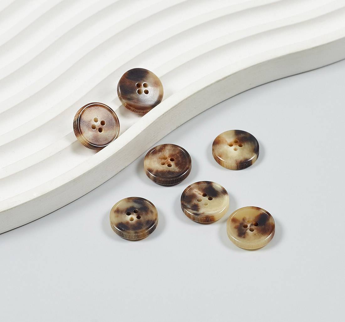 Пуговица на 4 прокола из натурального рога, блестящая, рифленый гурт. Цвет светло-коричневый в наличии