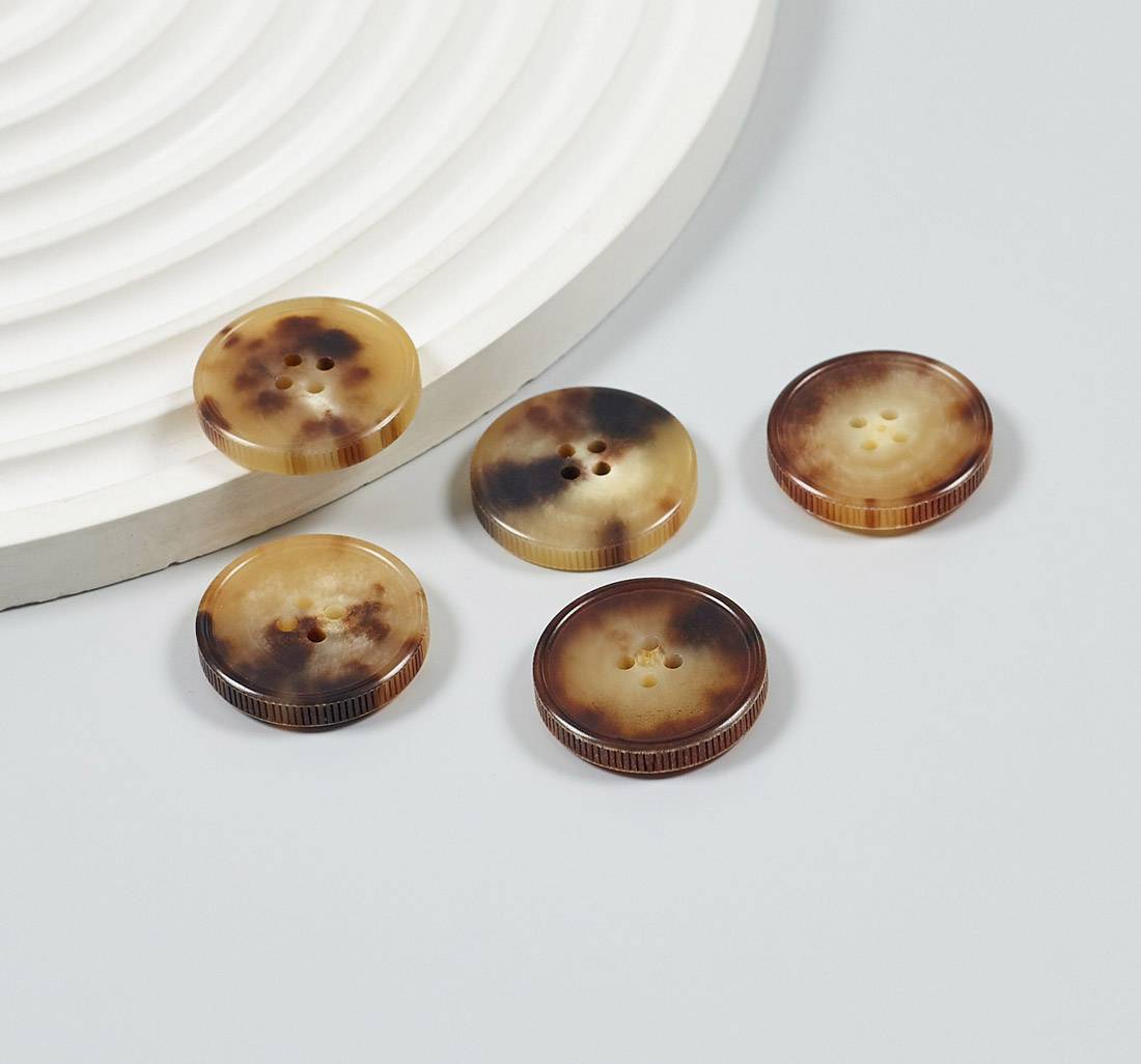 Пуговица на 4 прокола из натурального рога, блестящая, рифленый гурт. Цвет светло-коричневый в наличии