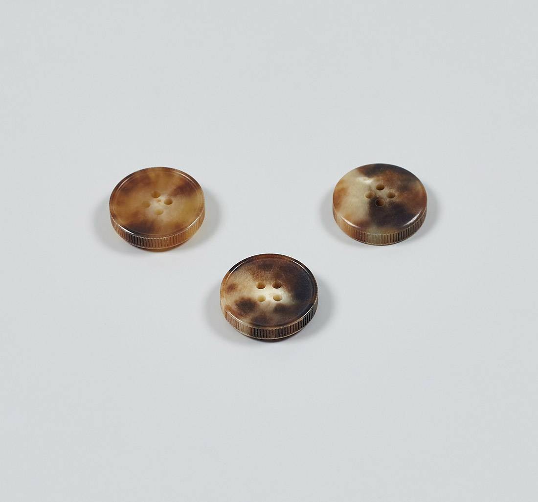 Пуговица на 4 прокола из натурального рога, блестящая, рифленый гурт. Цвет светло-коричневый в наличии