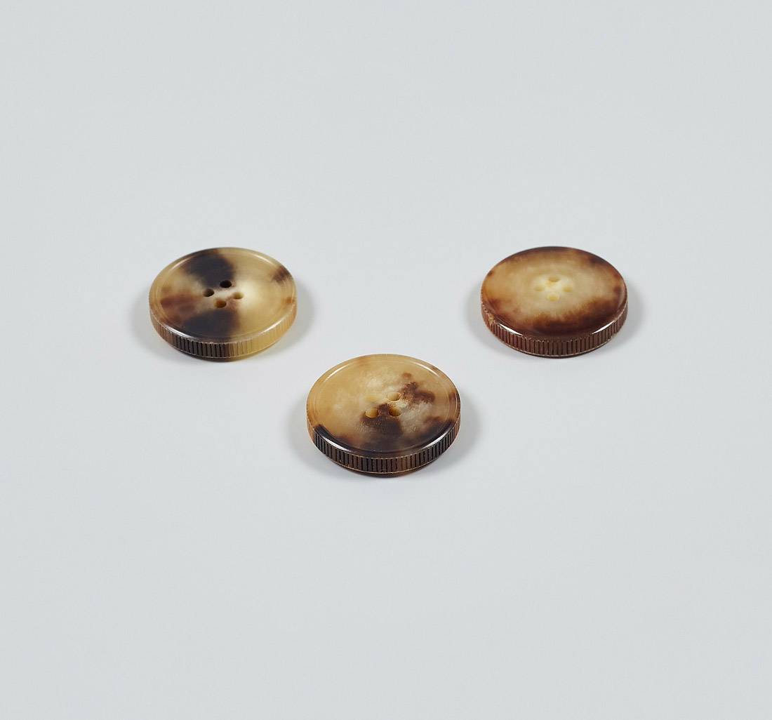 Пуговица на 4 прокола из натурального рога, блестящая, рифленый гурт. Цвет светло-коричневый в наличии