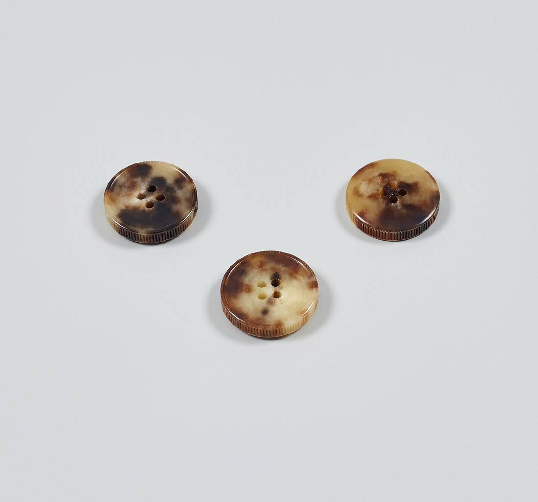 Пуговица на 4 прокола из натурального рога, блестящая, рифленый гурт. Цвет светло-коричневый в наличии